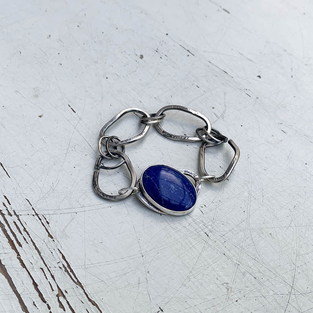 zilveren schakelarmband met een edelsteenschakel