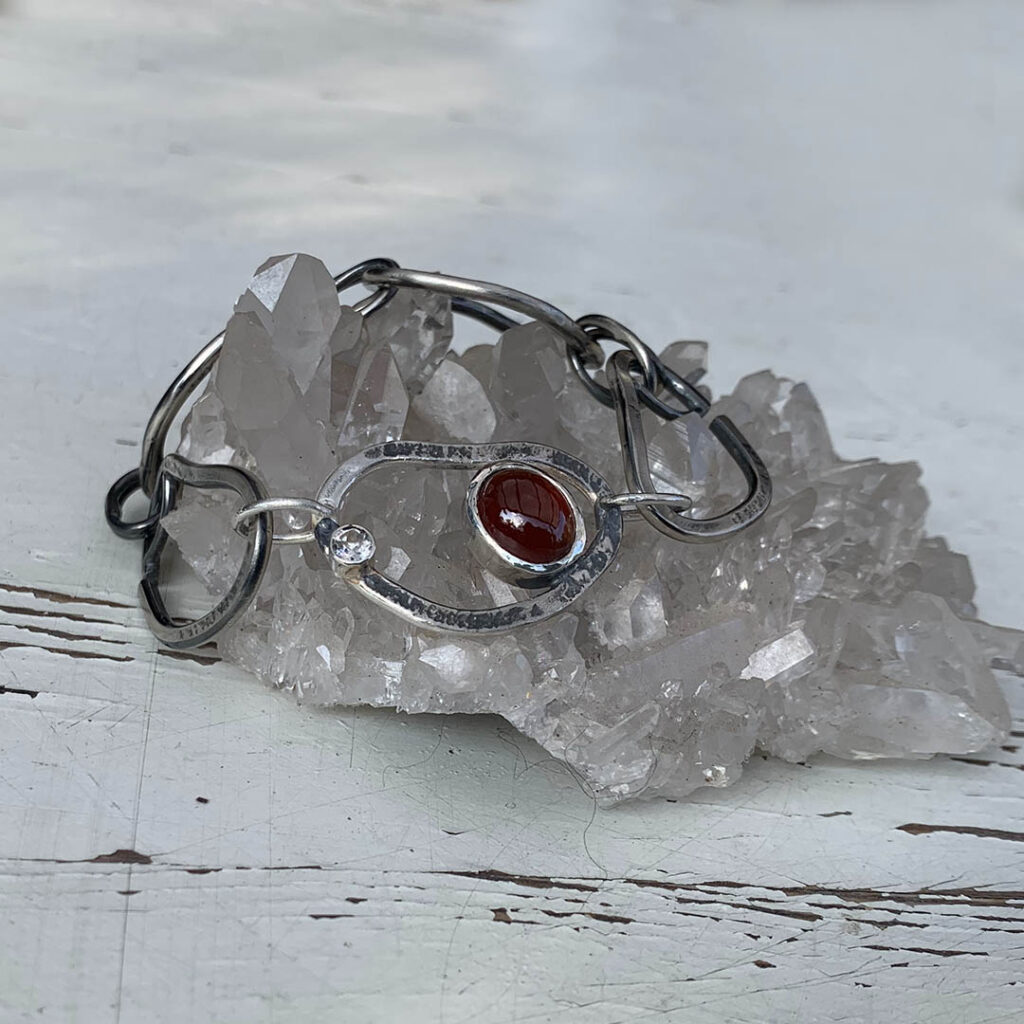 Schakelarmband van zilver met granaat en witte topaas